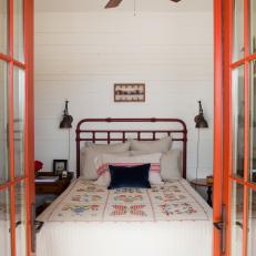 Red French Doors Open to White Farmhouse Bedroom