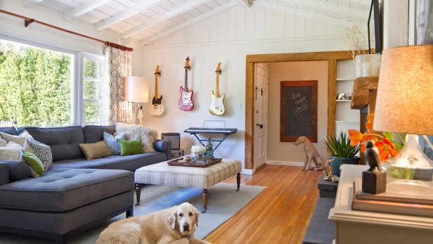 White Living Room With Gray Sectional, Large Dog, Guitars on Wall