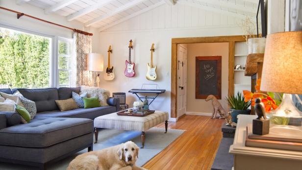 White Living Room With Gray Sectional, Large Dog, Guitars on Wall