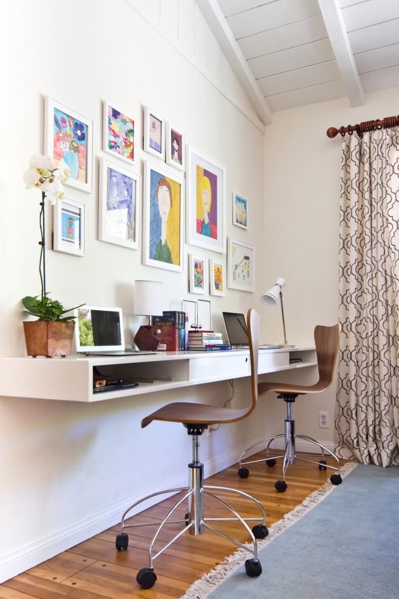 Espace de travail blanc avec bureau modulaire, chaises à disque en bois, mur de galerie