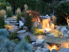 Beautifully Landscaped Yard With Boulder Staircase, Mixed Greenery and Lit Waterfall 