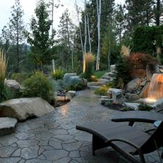 Elegantly Landscaped Patio With Custom Waterfall and Wicker Lounge Chairs 