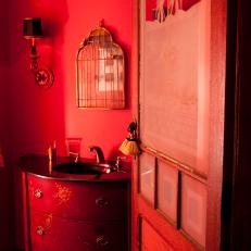 Eclectic Bathroom With Red Walls and Funky Mirror