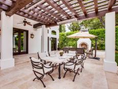 Pergola With Wood Beams and White Columns Over Outdoor Dining Area