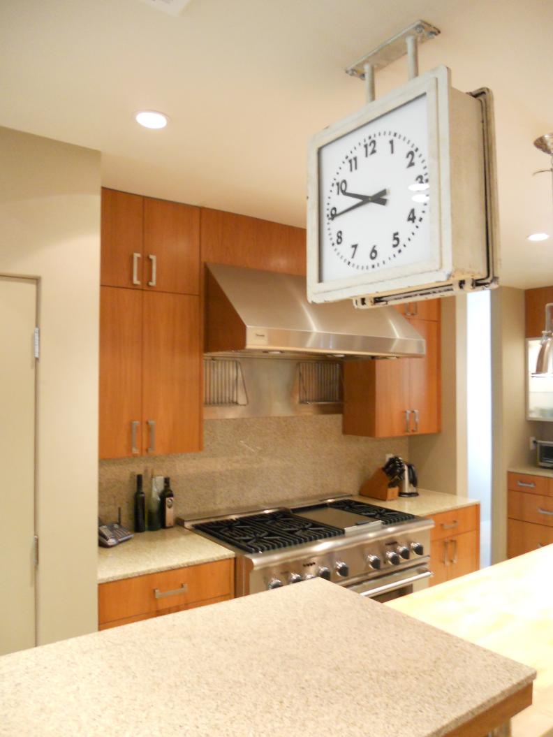 White Clock in Small Kitchen With Pale Wood Cabinets