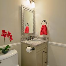Traditional Bathroom With Marble Countertop and Decorative Red Accents 