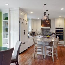 Bright, Open Traditional Eat-In Kitchen With White Cabinetry and Hardwood Flooring  