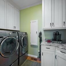 Traditional Green Laundry Room With White Cabinetry