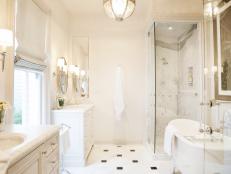 Large White Bathroom With Clawfoot Tub and Glass-Enclosed Shower