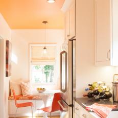 Orange and White Kitchen With Stainless Refrigerator