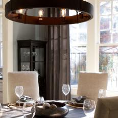 Gray Dining Room With Wheel-Shaped Chandelier