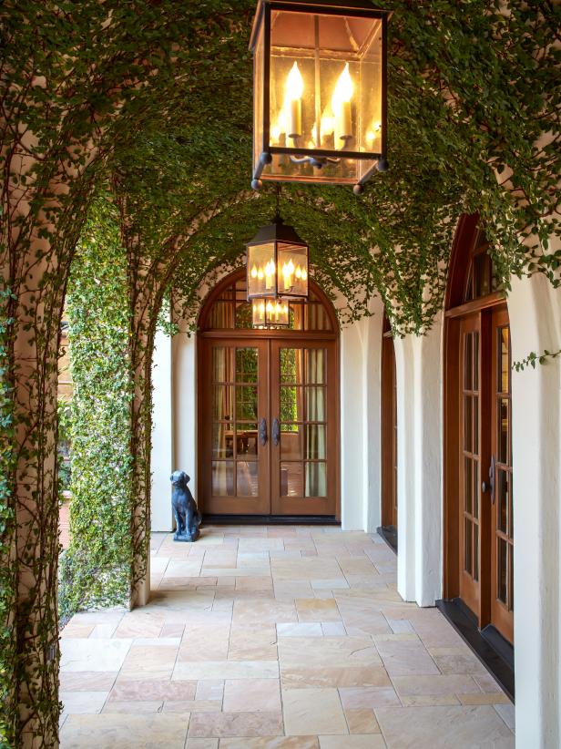 Vine-Covered Arched Entryway With Hanging Lanterns