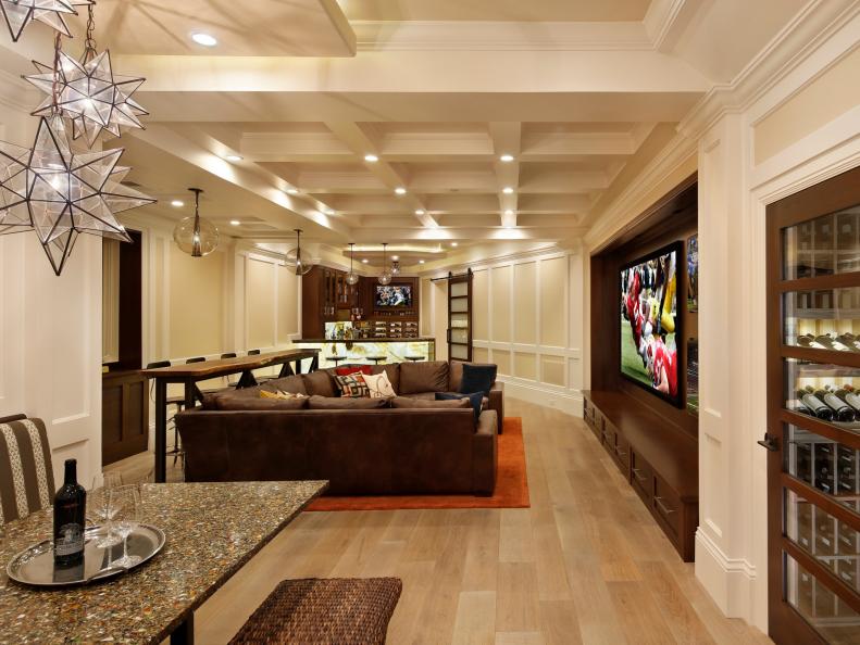 Neutral Room With Brown Sectional, Waffled Ceiling and Glass Pedants