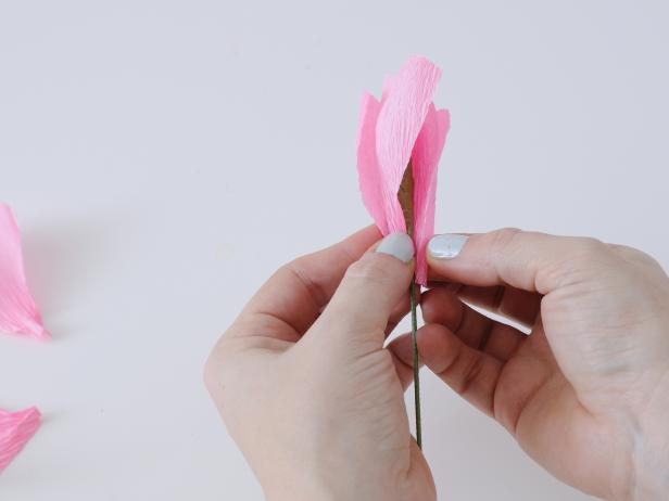 Arrange 3-5 inner petals, and secure with floral tape. Continue to add petals in a circular motion around the stamen, and secure with floral tape every few petals.
