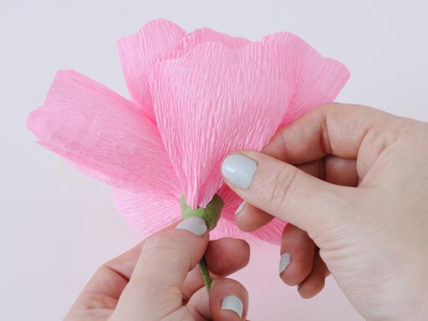 Continue to add petals in a circular motion around the stamen, and secure with floral tape every few petals.