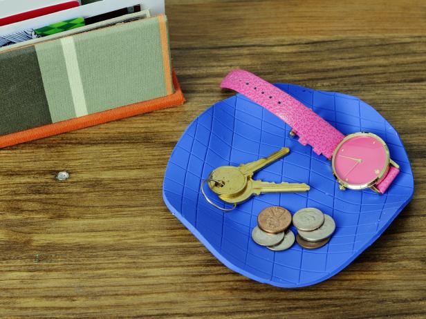 Roll out bakeable clay and add a pattern with basic household items, like a pencil eraser or a piece of lace. Bake and fill with jewelry, keys or other household items.