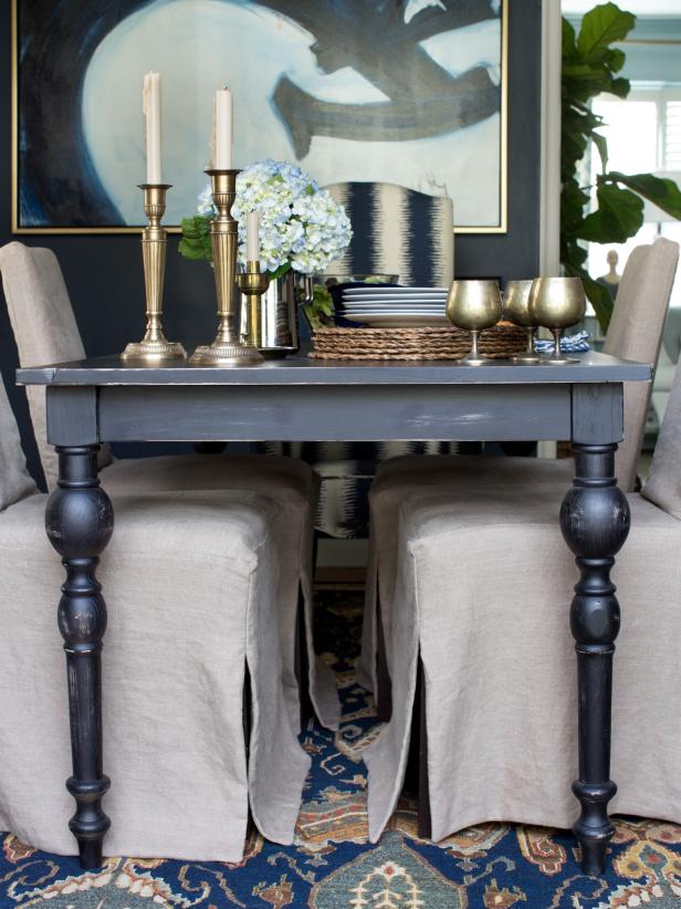 Metal candlesticks and goblets on distressed black dining table