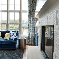 White Brick Fireplace Next to Blue Velvet Sofa