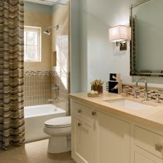 Pale Blue Bathroom With Tiled Backsplash and Shower
