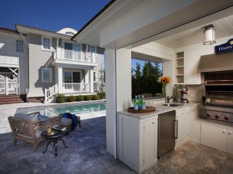 Outdoor Kitchen With Travertine Tile and Swimming Pool