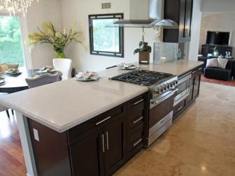 White Kitchen With Dark Wood Island, White Countertops and Glass Hood