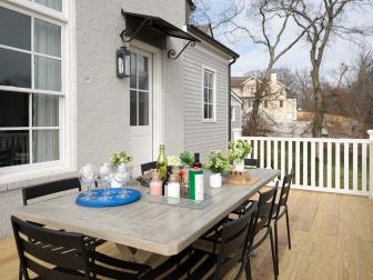 Wood Deck With White Railing, Gray Dining Table and Metal Chairs