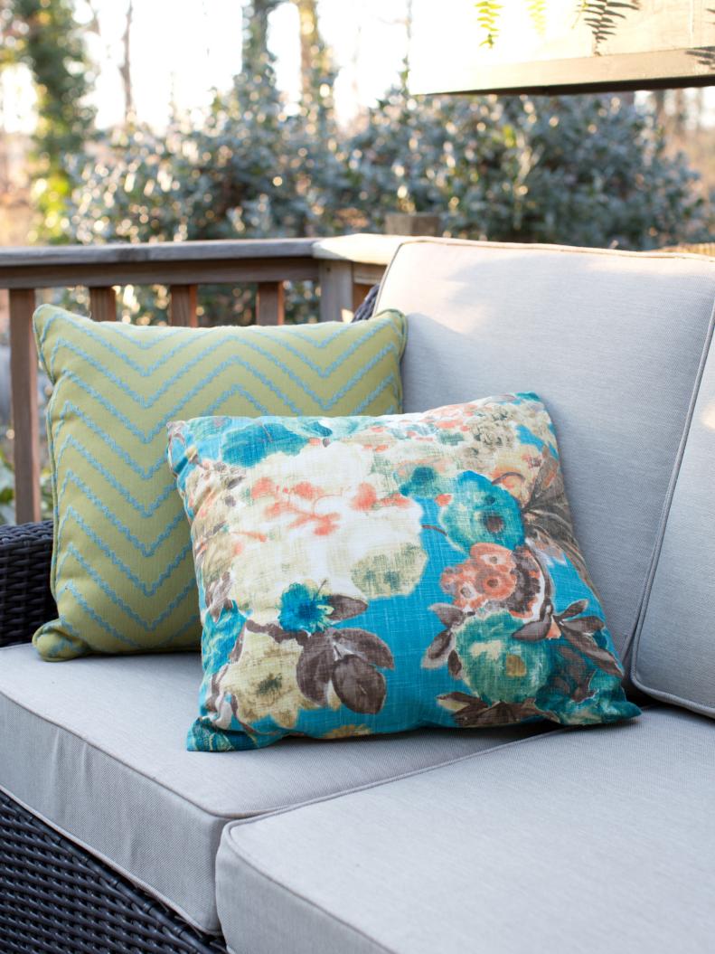 Blue and Green Pillows on a Gray Outdoor Sofa. 