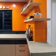 Bright Orange Kirchen With Concrete Countertops and Floating Shelves
