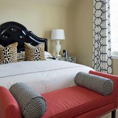 A Bedroom Mixes Animal Print Pillows With an Elegant Coral Bench