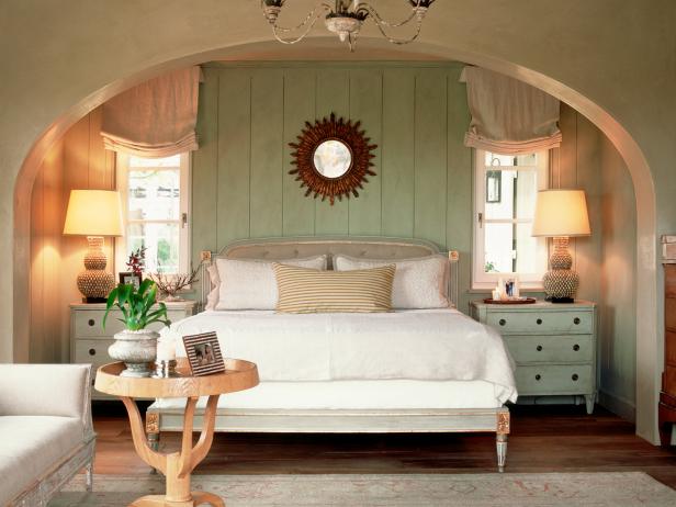 A French Inspired Bedroom With A Sunburst Mirror Centerpiece