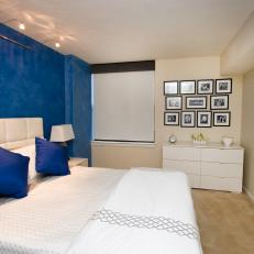 Blue and White Bedroom With Accent Wall and Framed Collage Art