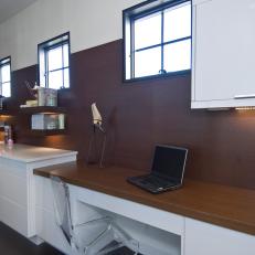 White Modern Workspace With Dark Wood Paneling and Built-In Desk