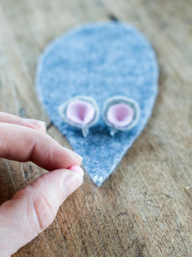 Use all-purpose, fabric or hot glue gun to attach ears, nose and eyes to felt mouse body