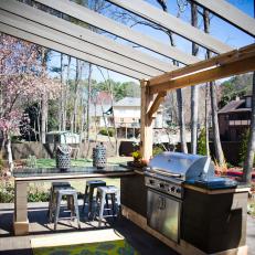 Outdoor Kitchen With a Large Grill and Brightly Colored Rug