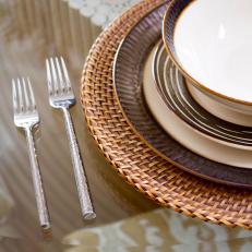 Glass-Topped Dining Table With Brown-and-White Place Setting