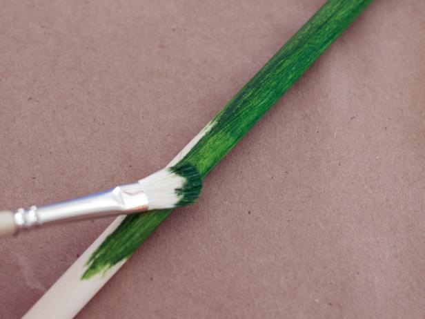 Paint dowel for cat spinner toy with one to two coats of green acrylic craft paint and allow to dry. Tip: Hang dowel by a paperclip threaded through the drilled hole to paint and allow paint to dry.