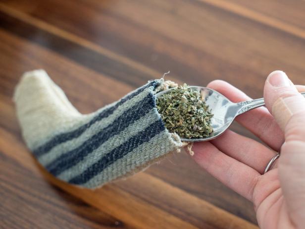 Use a spoon to fill stocking toy with dried catnip.