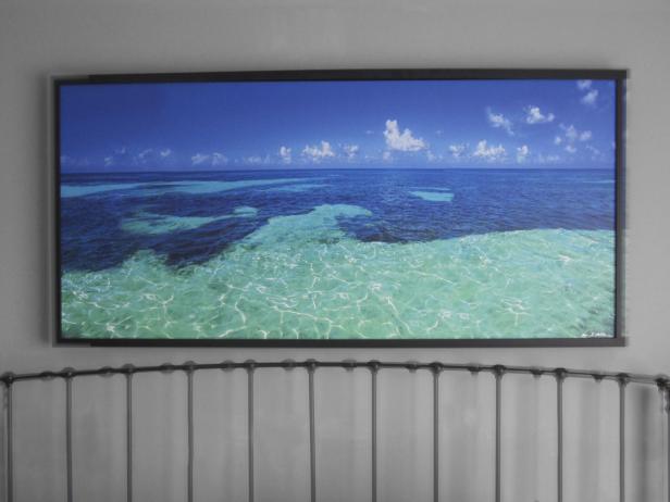 An ocean picture above headboard and bed.