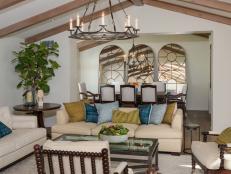 Neutral Mediterranean Living Room With Chandelier and Vaulted Ceiling