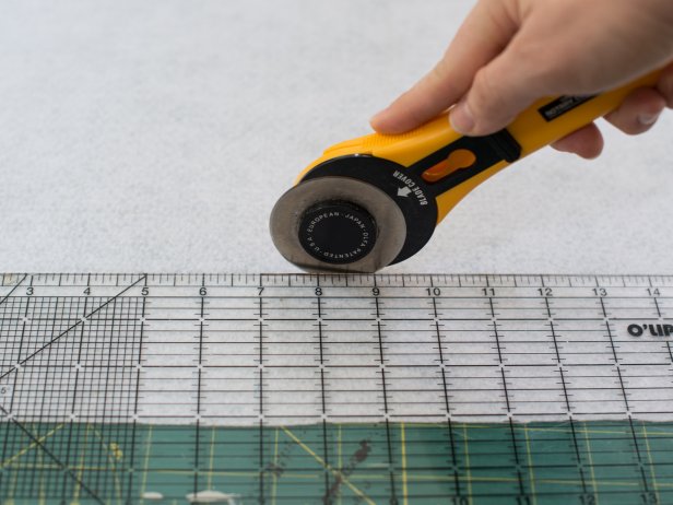 Using a rotary cutter, clear ruler and cutting mat, cut the remaining red felt and all of the white felt into 3&quot; wide strips for fringe.