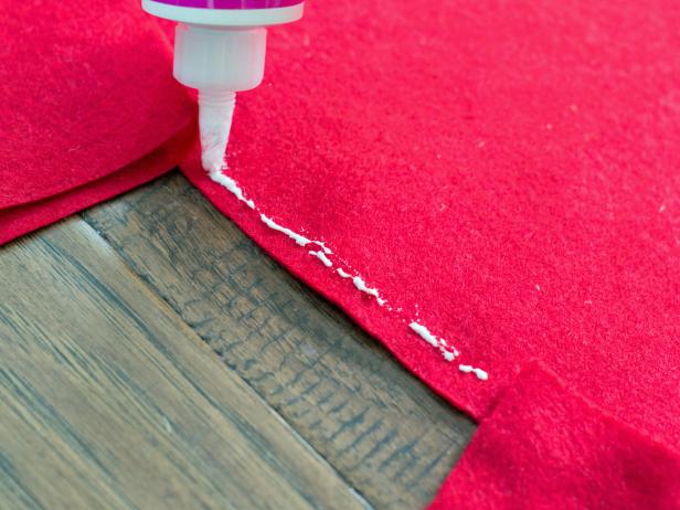Starting at the outside edge of skirt, apply a bead of fabric or felt glue. Press the connected edge of the red felt fringe into the glue. Repeat until one full row is completed.