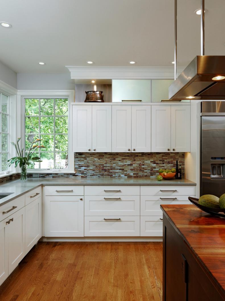Neutral Kitchen With Mosaic Backsplash, White Cabinetry, Wood Counter