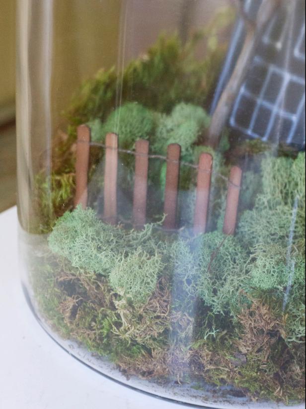 To create a spooky Halloween terrarium, cover the bottom in moss. Cut a haunted house out of tag board and attach to the inside with tape. Add a cute ghost made from a 1’foam ball wrapped in tissue. Push a length of miniature fence into the moss near the front of the jar. Add additional texture with clumps of reindeer moss, then place lid on top of the jar, adjusting the fishing line's length, if necessary, so the ghost hangs at the right level.