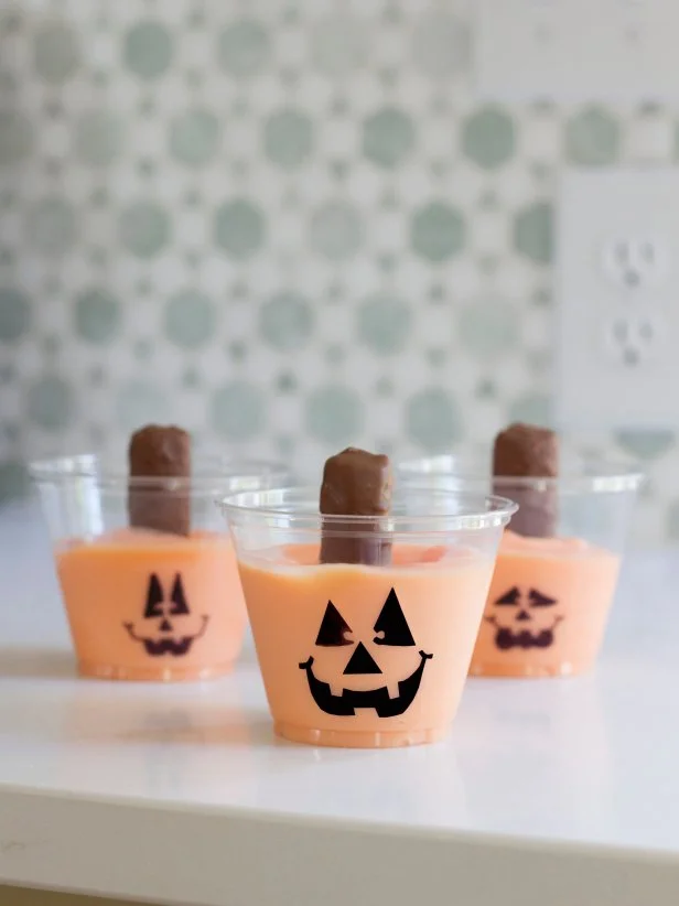 Treat small Halloween guests to a snack size cup of pudding that looks like a mini jack-o'-lantern. They're a snap to make so the kids can even help whip them up before gobbling them up.