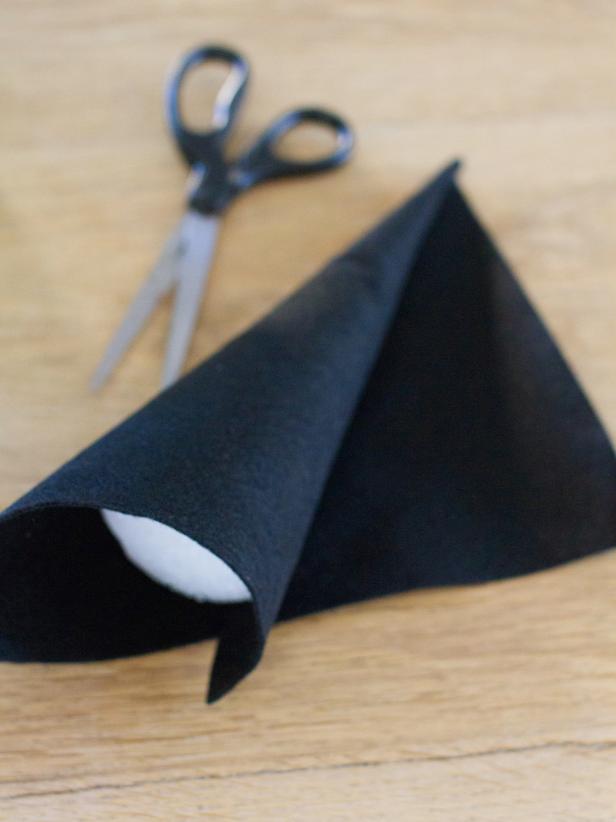 Cover a 6&quot; foam cone with black felt. Use hot glue to secure it and trim off excess felt around the bottom of the cone