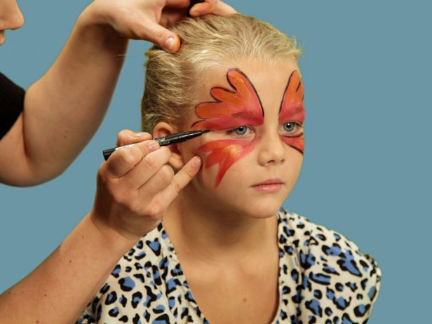 To transform your child or yourself into a beautiful butterfly for Halloween, create one large wing over each eyelid and up the forehead using face paint and a wide brush. Use black liquid eyeliner and line the edge of the makeup. To add highlights to the wings, use white face paint and a small makeup brush to randomly dot white on each wing tip, right on top of the black lines. Also, add a dot to the inside of the eye. Use your fingers and carefully apply some kid-friendly gel glitter inside the black lines on the wings. Be sure to keep the glitter away from the eyes.