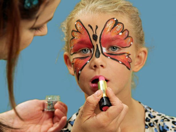 To transform your child or yourself into a beautiful butterfly for Halloween, create one large wing over each eyelid and up the forehead using face paint and a wide brush.  Line wings with black eyeliner and use white face paint to add dots to wings. Create the butterfly's body between the wings by first drawing an oval above the nose with a black eyeliner pencil. From the bottom of the oval, draw a long, skinny teardrop shape to the tip of the nose to create the butterfly's body. Above the oval, draw lines onto the forehead that curl slightly at the top to resemble antennae. Finish the look with sparkly pink lips. First apply pink lipstick, and then add a dot of glitter right in the center of the lips for shimmer. A black leotard, tights and wings are all you need to complete your costume.