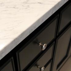 Closeup on Black Cabinet With White Marble Countertop