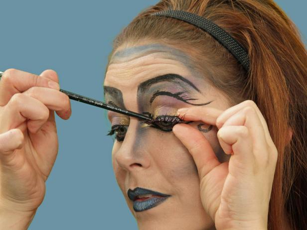 Finish the look with false eyelashes. With eyelash glue, attach the false lashes to the top lash line.
