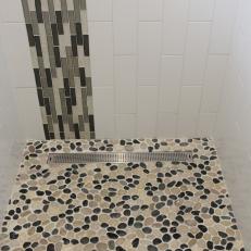Neutral and Black Mosaic Pebble Shower Floor With Vertical Tile Stripe